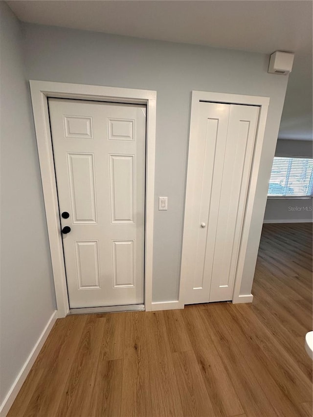 interior space featuring baseboards and wood finished floors