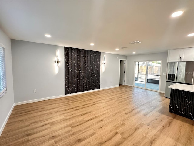 unfurnished living room featuring recessed lighting, baseboards, visible vents, and light wood finished floors