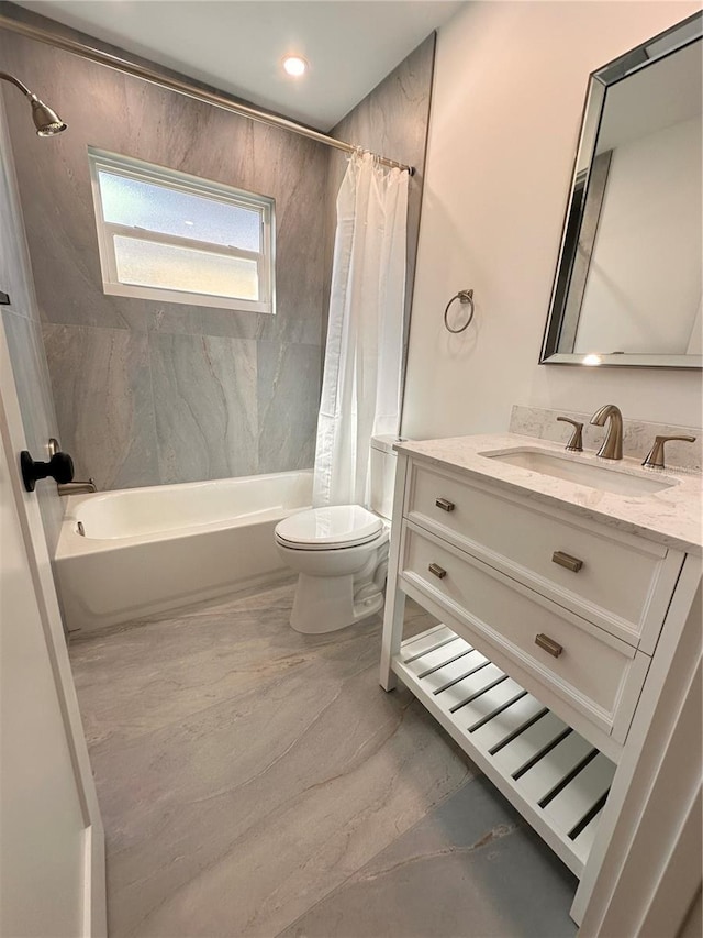 bathroom featuring marble finish floor, vanity, shower / bath combo with shower curtain, and toilet