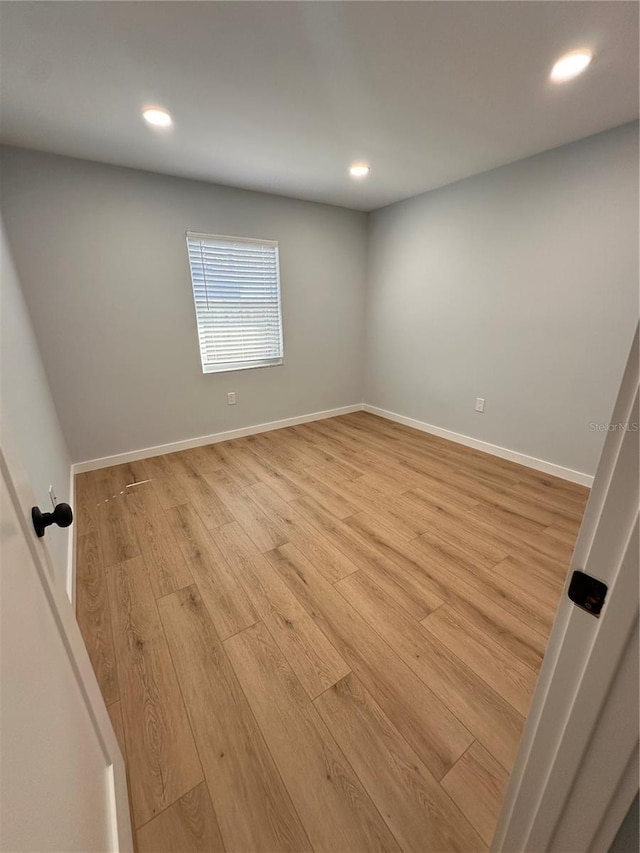 empty room featuring baseboards, recessed lighting, and light wood-style floors