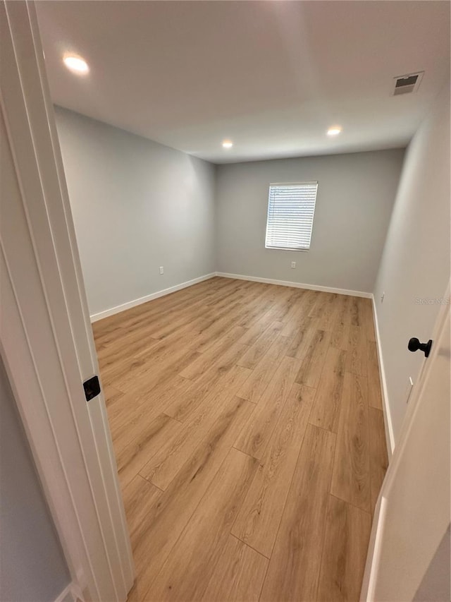 spare room with light wood-style flooring, visible vents, baseboards, and recessed lighting