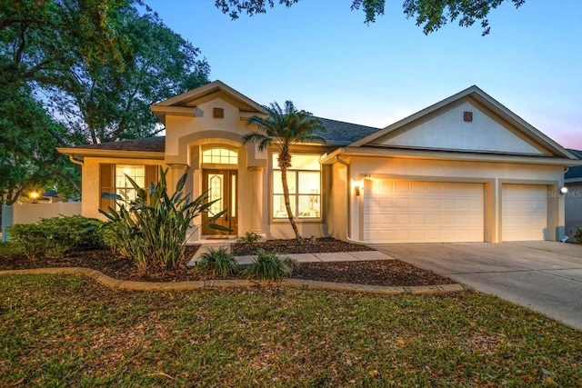 view of front of home with concrete driveway, a garage, and stucco siding