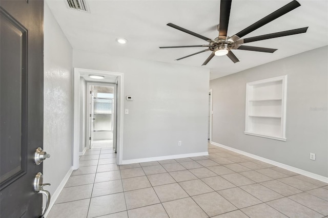 unfurnished room featuring visible vents, built in features, ceiling fan, and baseboards