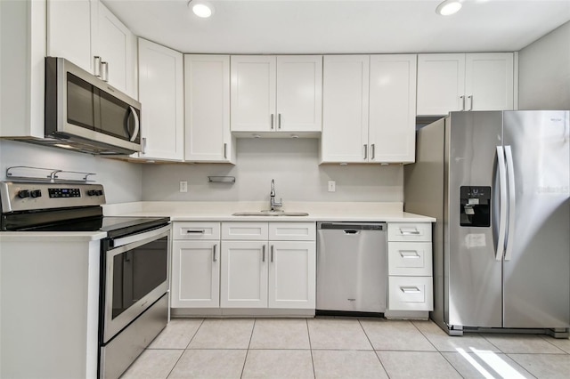 kitchen with appliances with stainless steel finishes, light countertops, white cabinetry, and a sink