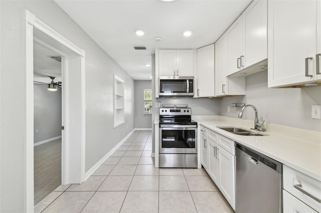 kitchen featuring stainless steel appliances, white cabinets, visible vents, and a sink