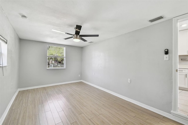 unfurnished room featuring a ceiling fan, baseboards, visible vents, and light wood finished floors