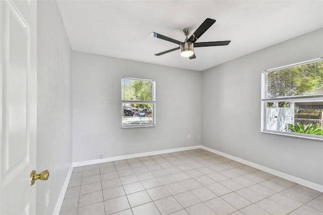 spare room with ceiling fan and baseboards