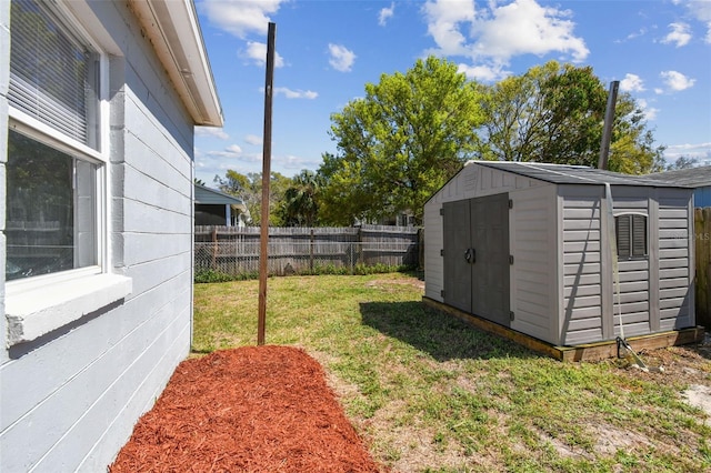 view of yard featuring an outbuilding, a shed, and a fenced backyard