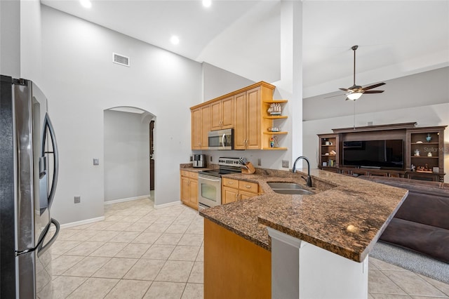 kitchen with arched walkways, visible vents, appliances with stainless steel finishes, a sink, and a peninsula