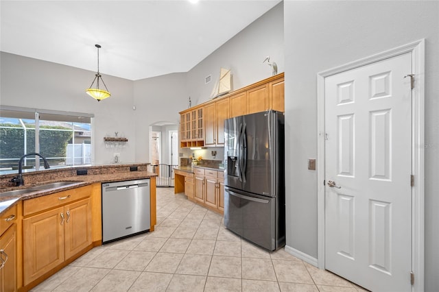 kitchen featuring light tile patterned floors, arched walkways, a sink, black fridge, and dishwasher