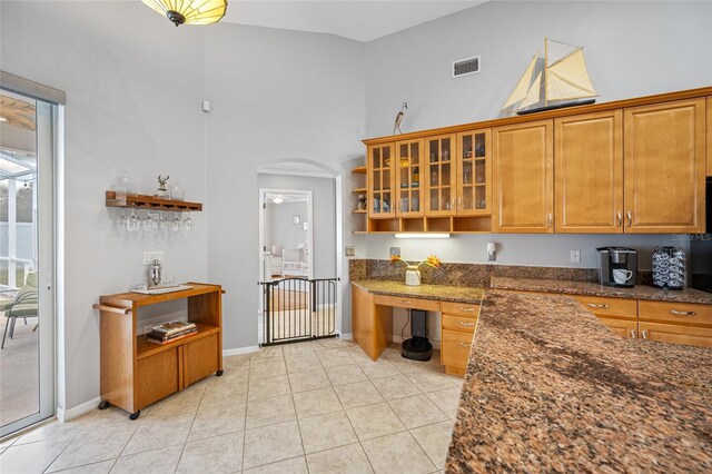 kitchen featuring visible vents, arched walkways, high vaulted ceiling, open shelves, and light tile patterned flooring