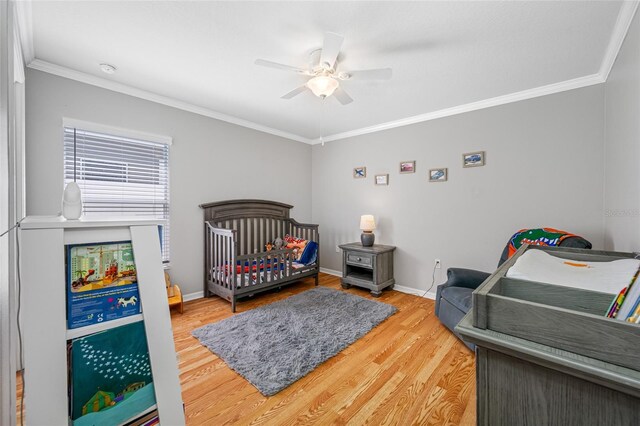 bedroom featuring ornamental molding, baseboards, and wood finished floors