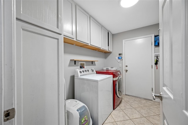 laundry room with cabinet space, washer and clothes dryer, and light tile patterned floors