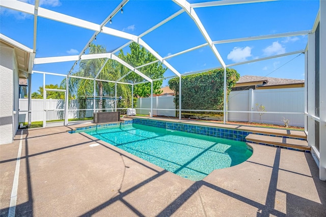 view of swimming pool featuring a patio area, a fenced backyard, a fenced in pool, and a lanai