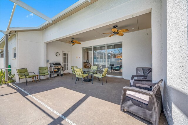 view of patio featuring a ceiling fan, outdoor dining space, a lanai, and grilling area