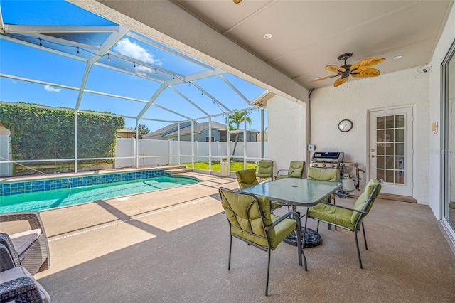 view of patio / terrace featuring a lanai, a fenced in pool, fence, and a ceiling fan