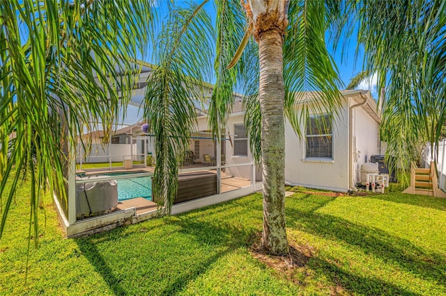 back of property with a fenced in pool, a yard, stucco siding, fence, and a lanai