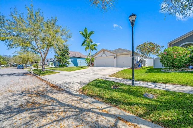 view of front of house featuring a garage, concrete driveway, fence, and a front lawn