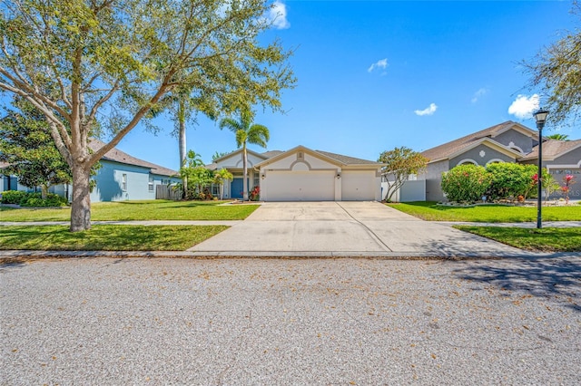 ranch-style house featuring an attached garage, driveway, and a front lawn