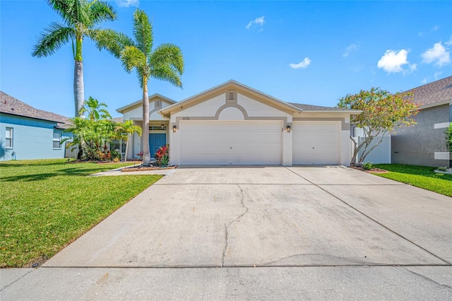 ranch-style home featuring an attached garage, driveway, a front yard, and stucco siding