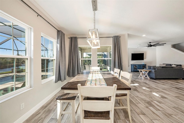 dining area featuring light wood-type flooring, a healthy amount of sunlight, ceiling fan, and baseboards