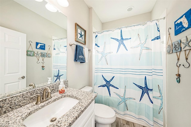 bathroom featuring toilet, curtained shower, and vanity