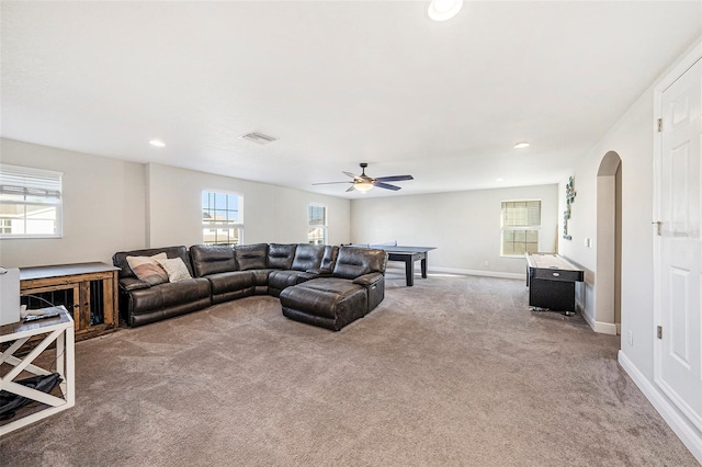 carpeted living area featuring visible vents, baseboards, arched walkways, ceiling fan, and recessed lighting