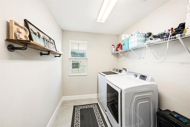 washroom featuring laundry area, baseboards, and washer and dryer