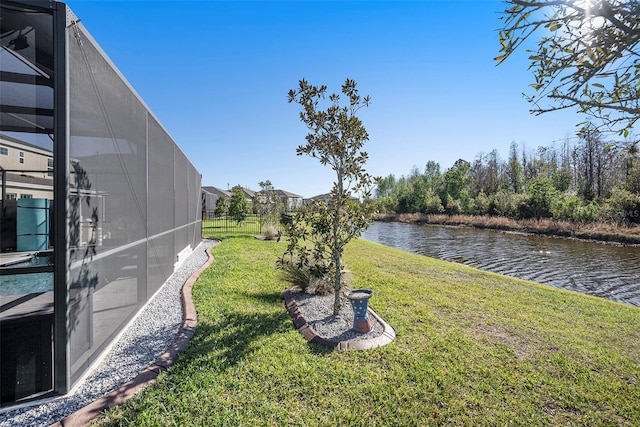 view of yard with a water view and glass enclosure