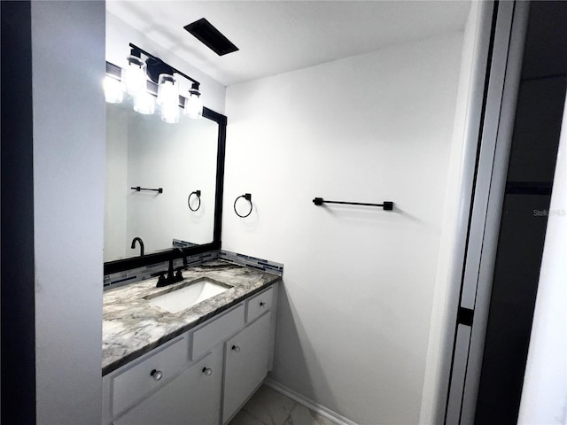 bathroom featuring marble finish floor, vanity, and baseboards