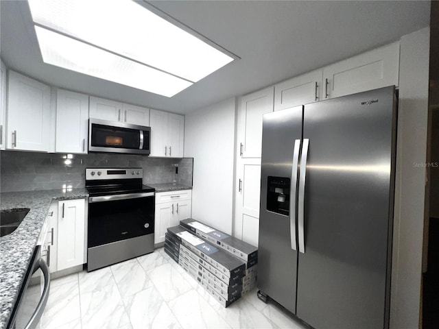 kitchen featuring marble finish floor, white cabinetry, and stainless steel appliances