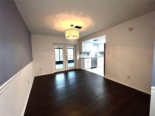 interior space with dark wood-style floors, french doors, a notable chandelier, a sink, and baseboards