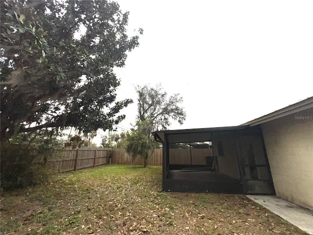 view of yard featuring a sunroom and a fenced backyard