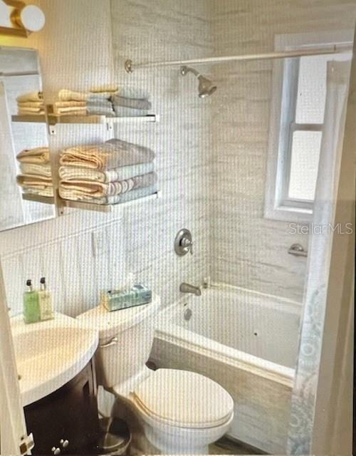 full bath with vanity, toilet, and shower / bath combo with shower curtain