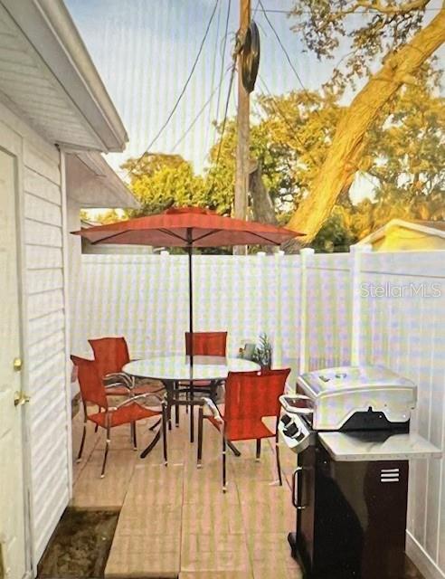 view of patio / terrace with outdoor dining space, a grill, and fence