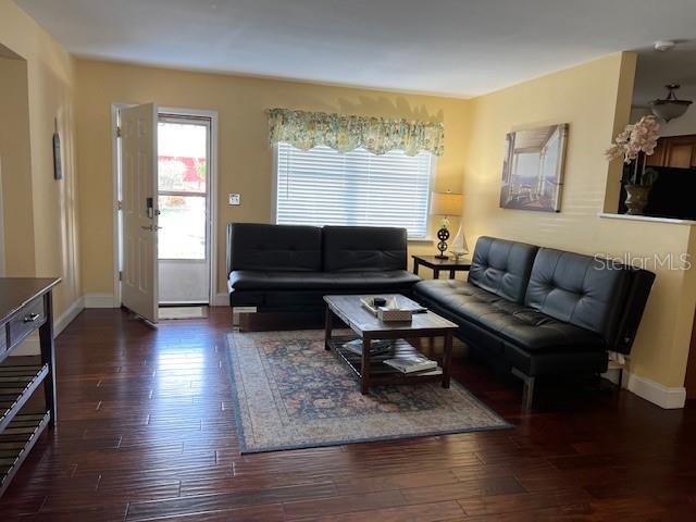 living area featuring baseboards and wood finished floors