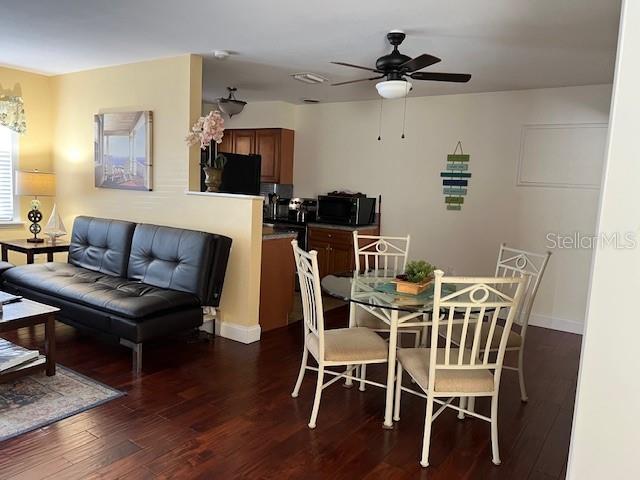 dining room featuring wood finished floors, baseboards, and ceiling fan