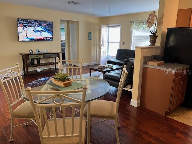 dining area featuring visible vents, baseboards, and wood finished floors