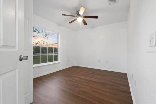 spare room with ceiling fan, wood finished floors, visible vents, and baseboards