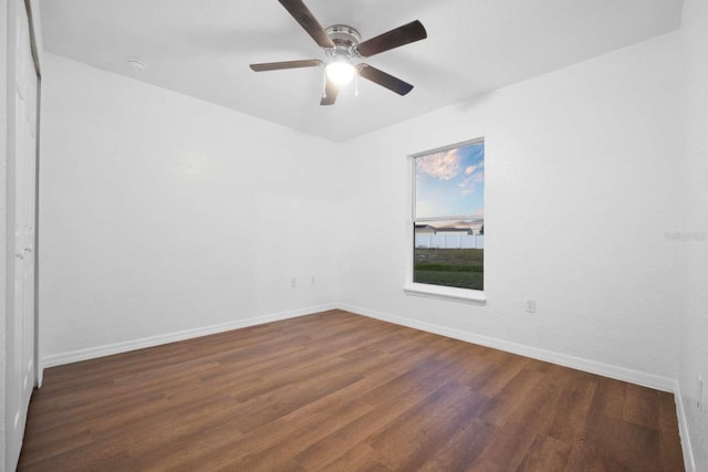 empty room featuring a ceiling fan, baseboards, and wood finished floors