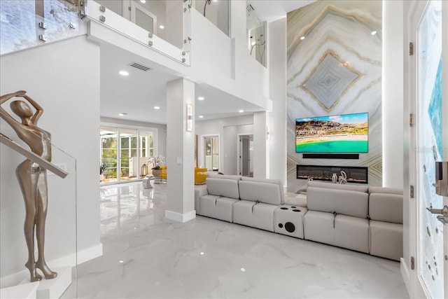 living room with recessed lighting, visible vents, and a towering ceiling