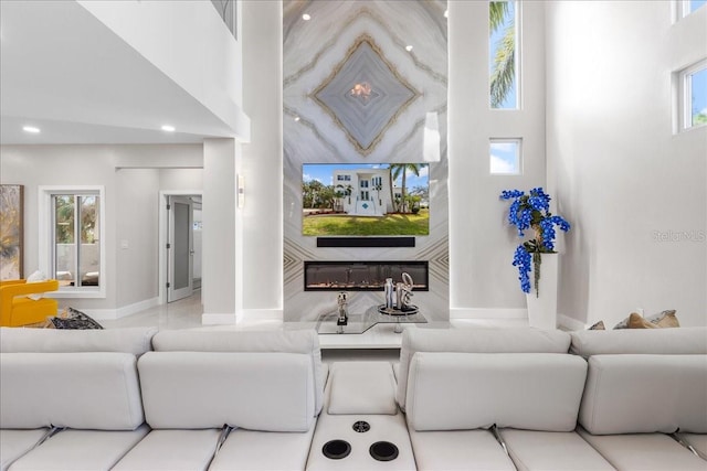 living area with recessed lighting, indoor wet bar, baseboards, and a towering ceiling