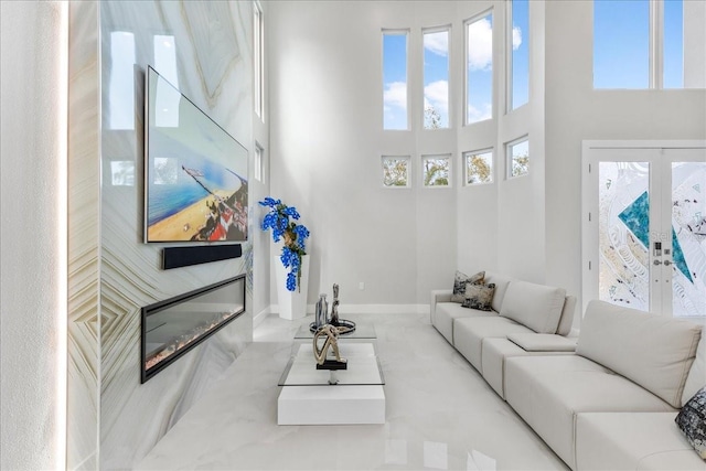 living area featuring a high ceiling and baseboards