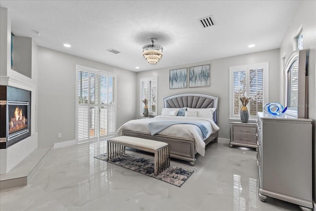 bedroom with a fireplace with flush hearth, baseboards, and visible vents