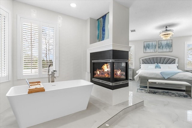 bedroom featuring recessed lighting, multiple windows, a multi sided fireplace, and visible vents