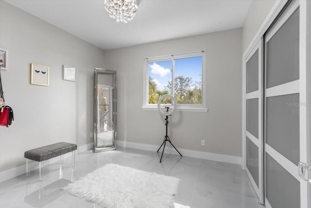 interior space featuring baseboards and a chandelier