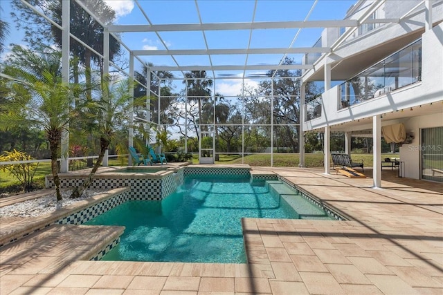 view of pool featuring glass enclosure, a pool with connected hot tub, and a patio area