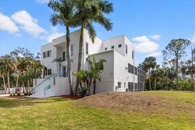 view of side of home featuring a lawn and stucco siding