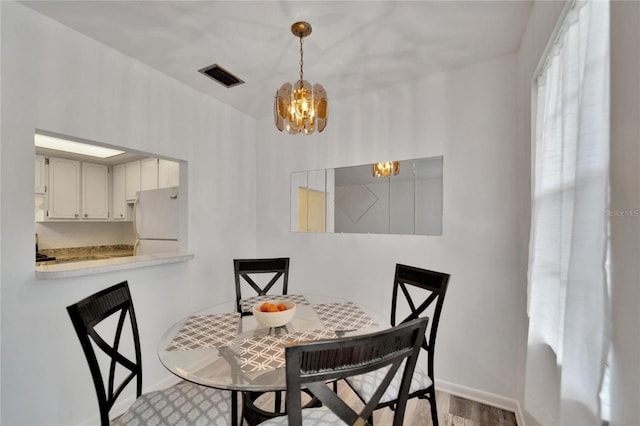 dining room featuring a chandelier, visible vents, and baseboards