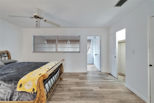 bedroom featuring visible vents, ceiling fan, baseboards, and wood finished floors